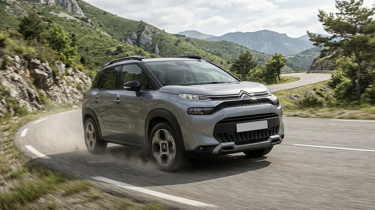 Citroën C3 Aircross Gris 2024 en pleine accélération sur une route sinueuse de montagne – C3 Aircross