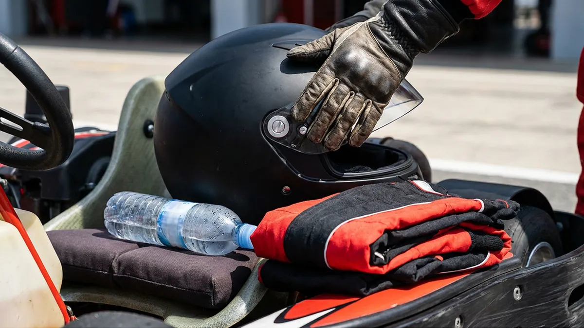Pilote préparant son casque, ses gants et sa bouteille d’eau avant la course, illustrant les conseils pour une session réussie au Maroc Racing Karting Agadir.