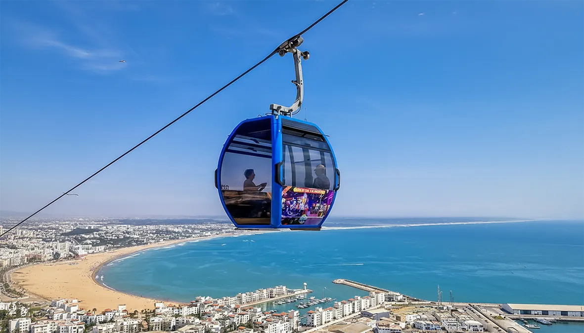 Cabine de téléphérique montant vers danialand avec vue sur la mer, la ville et les hauteurs d’Agadir Oufella