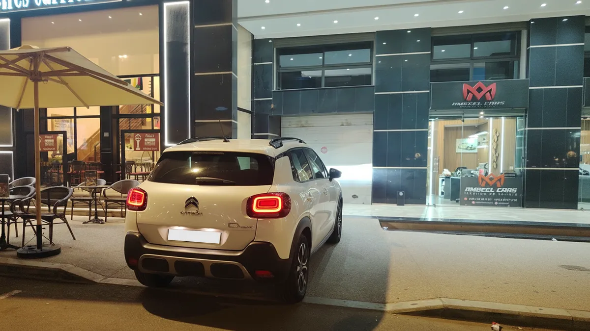 Intérieur d’une agence de location de voitures à Agadir avec un comptoir d’accueil, un décor chaleureux et une Citroën C3 Aircross blanche visible à travers la vitrine