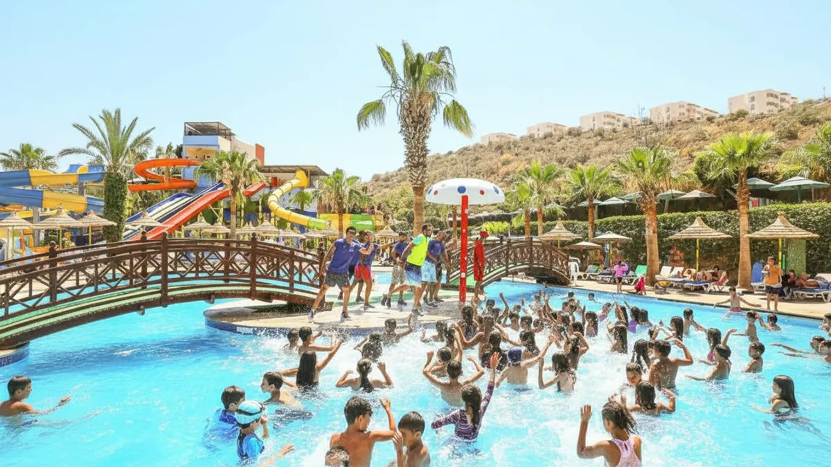 Familles et enfants s'amusant sur des toboggans et dans une aire pirate au parc aquatique atlantica park avec zones détente en arrière-plan – atlantica park