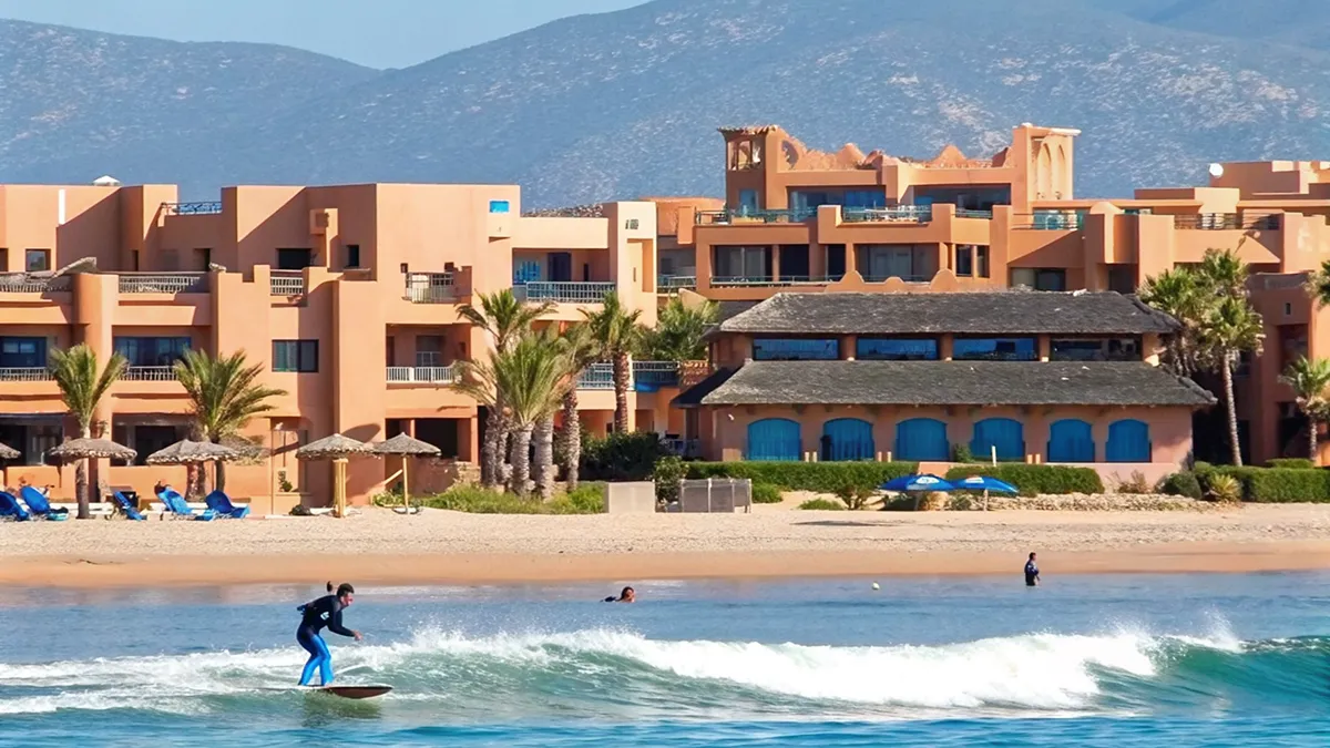 Plage sauvage d'Imi Ouaddar avec falaises ocre et village berbère à proximité d'Atlantica Park – atlantica park