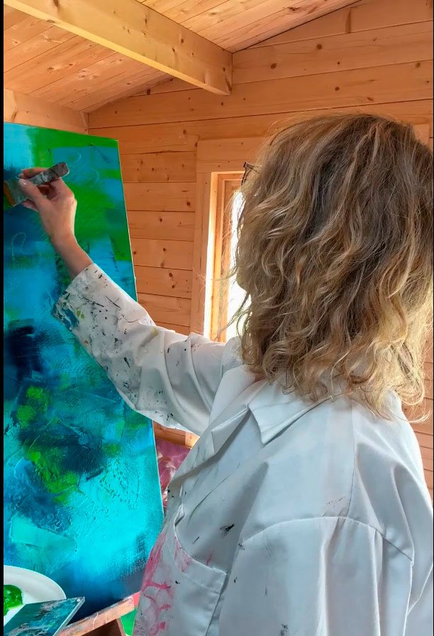 Kunstner maler et abstrakt maleri i sit atelier