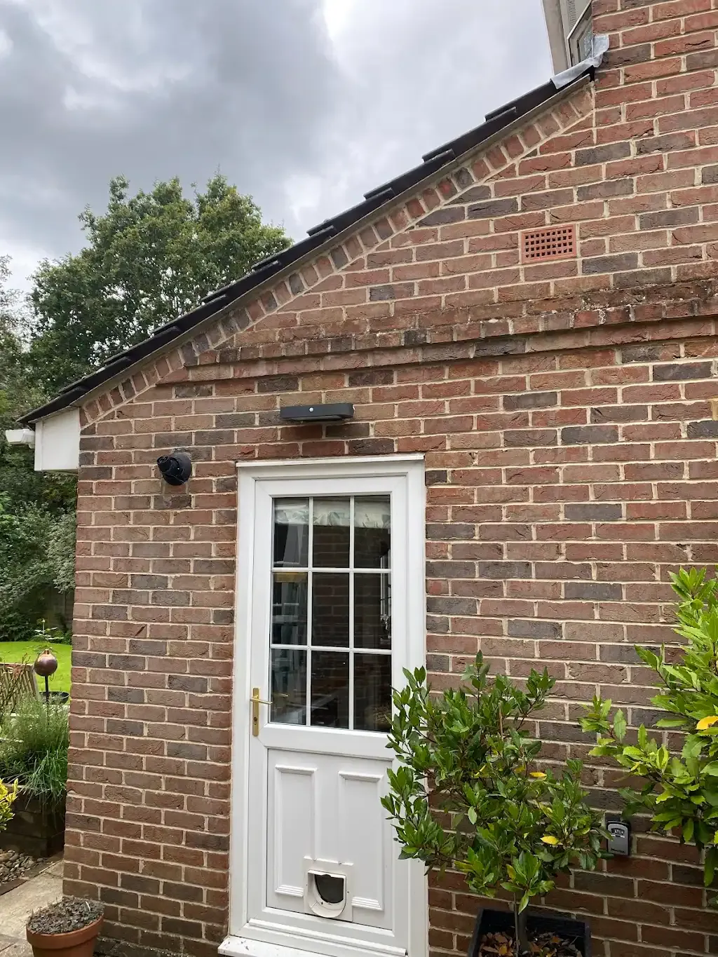 Pitched tiled roof and brick wall on a house extension.