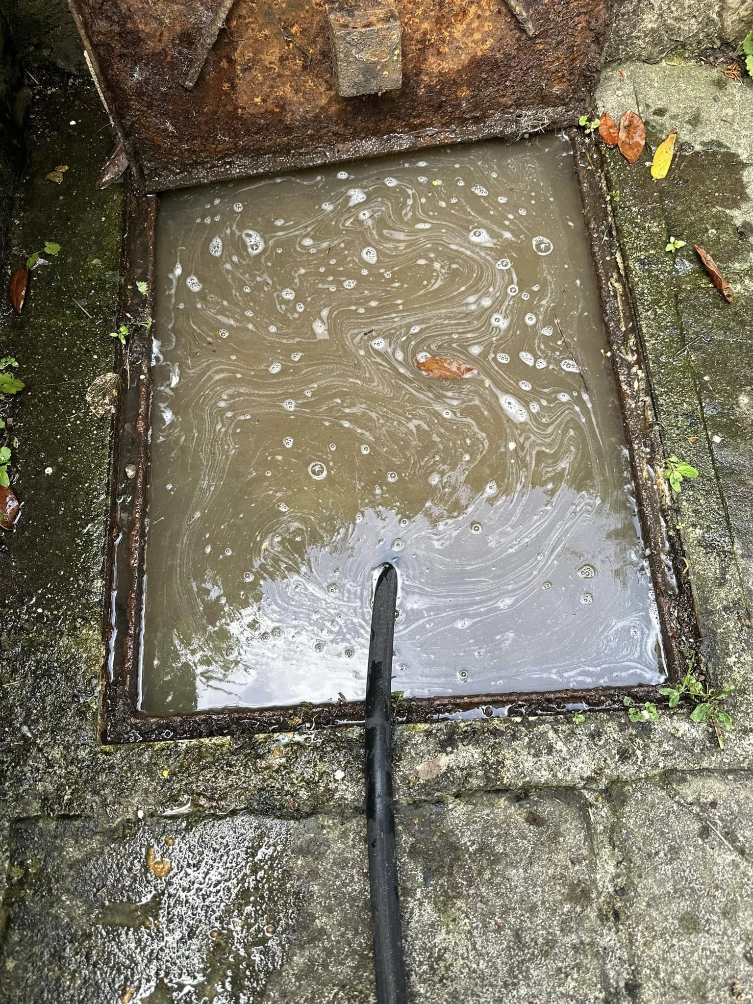 Blocked drain access point with standing water and high-pressure jetting hose