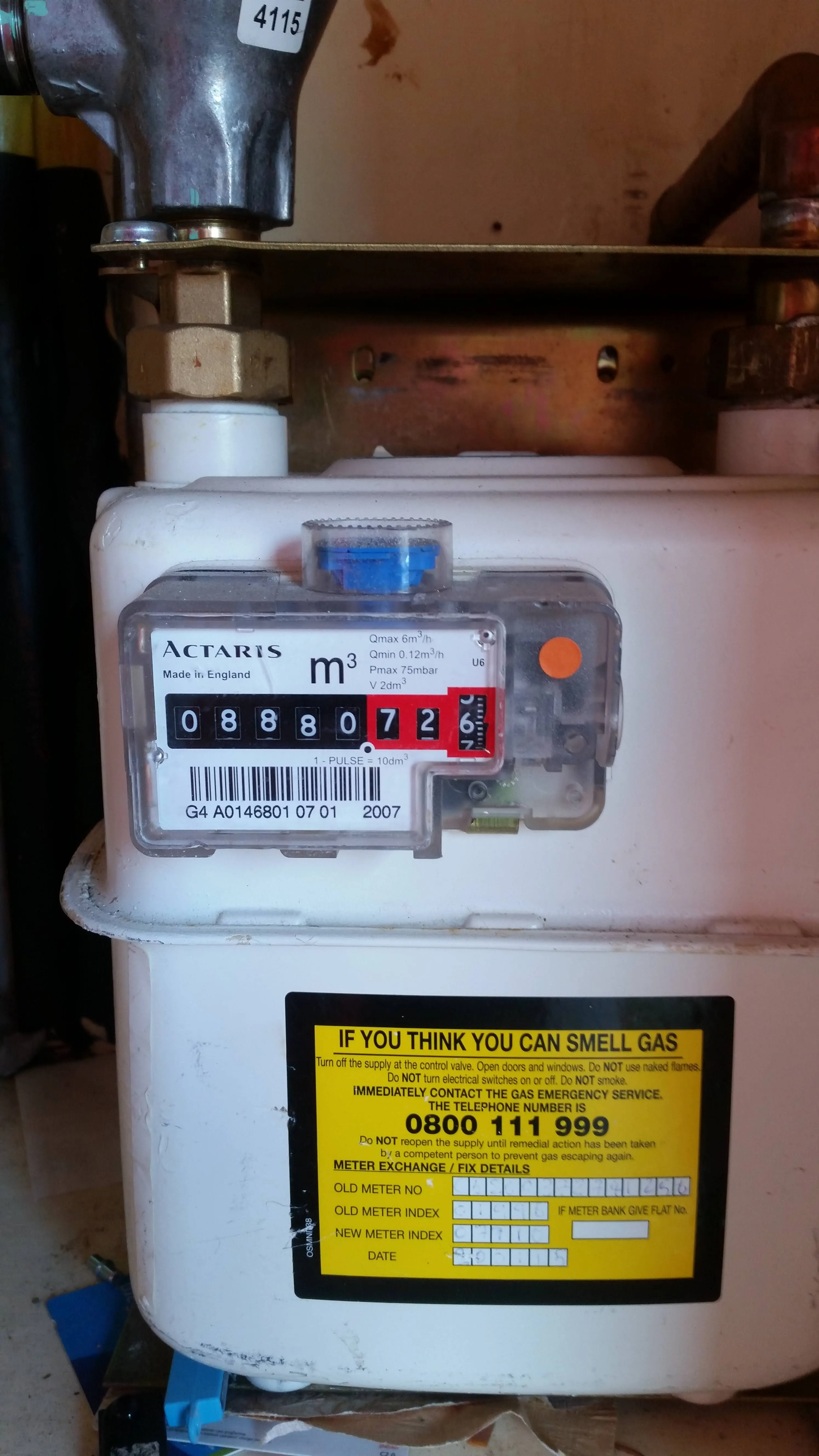 A domestic gas meter with a safety warning label.