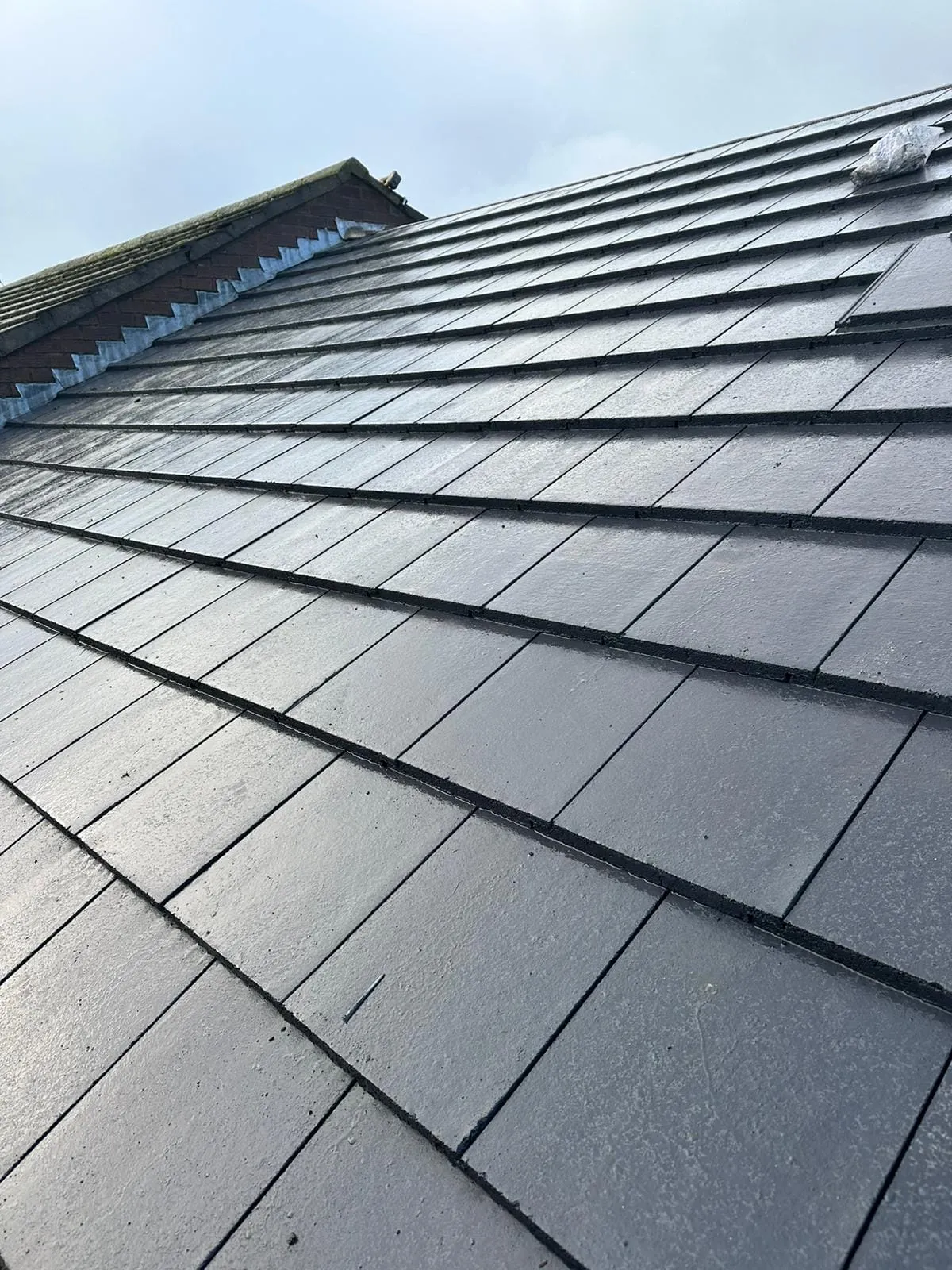 Detail of a modern grey tiled roof installation by Toptile Roofing