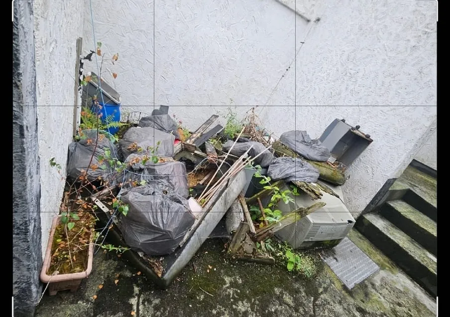 A cluttered outdoor space filled with general rubbish, household waste, and garden debris, highlighting the need for a rubbish removal service.