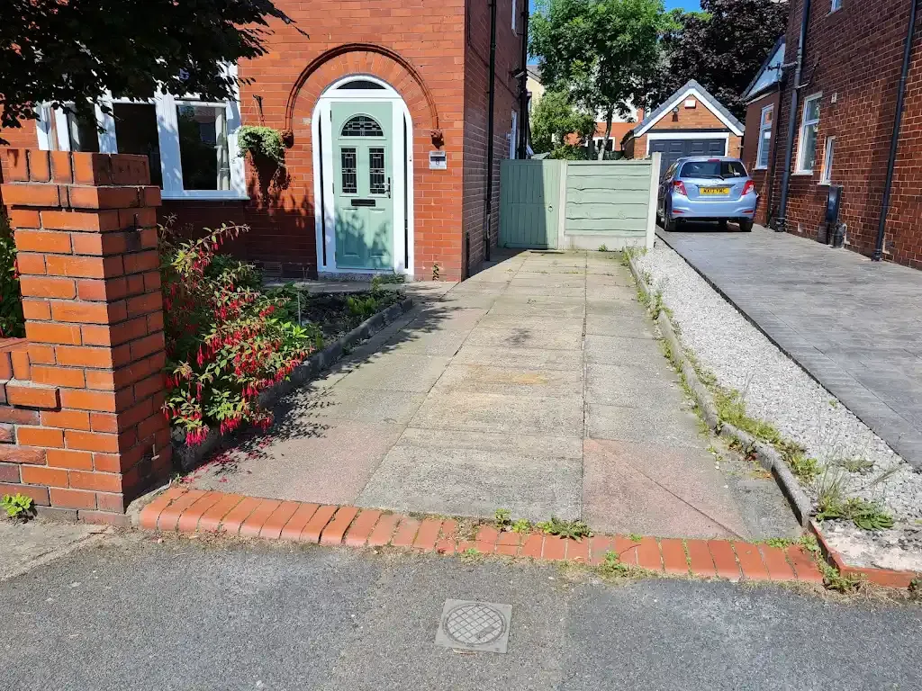View of a residential driveway with old concrete sections next to new block paving.