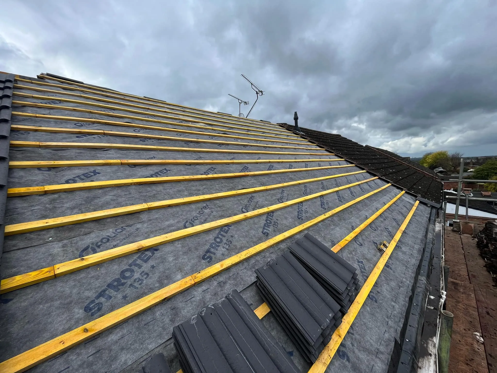 New roof installation in progress showing timber battens and breathable membrane on a pitched roof