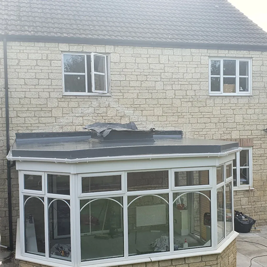 A new flat roof being installed on a residential extension or conservatory, showing the dark grey membrane material.