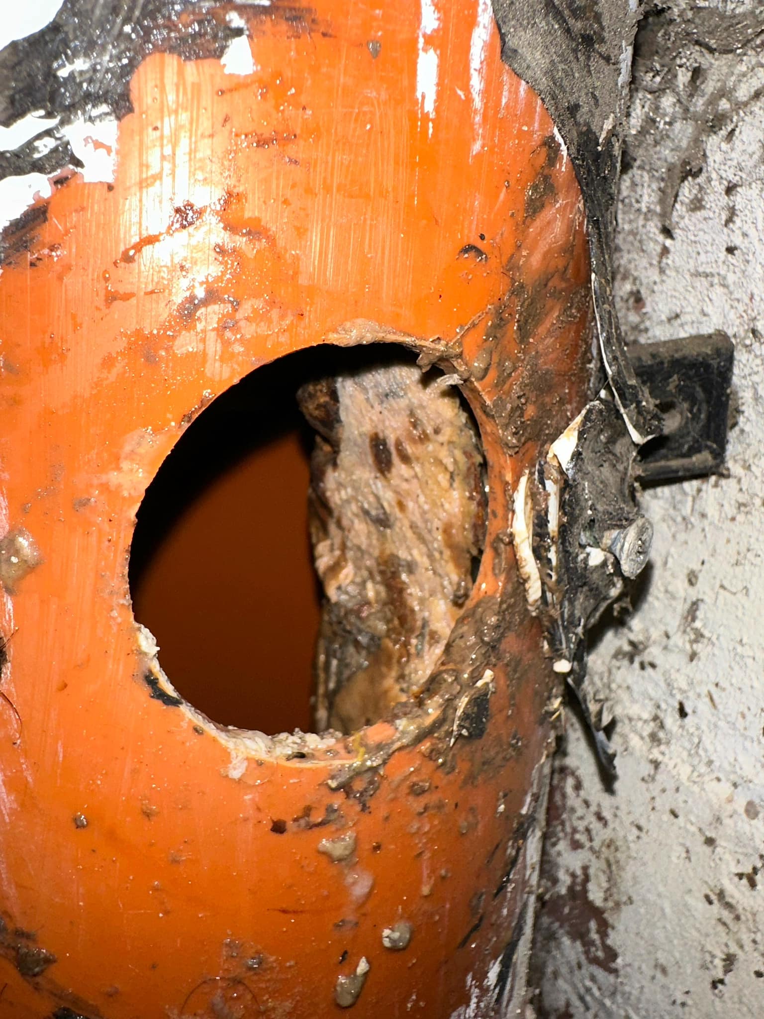 Damaged orange drainage pipe with visible internal blockage, illustrating a common issue that requires expert drain repair and unblocking services in Torquay and the Torbay area.