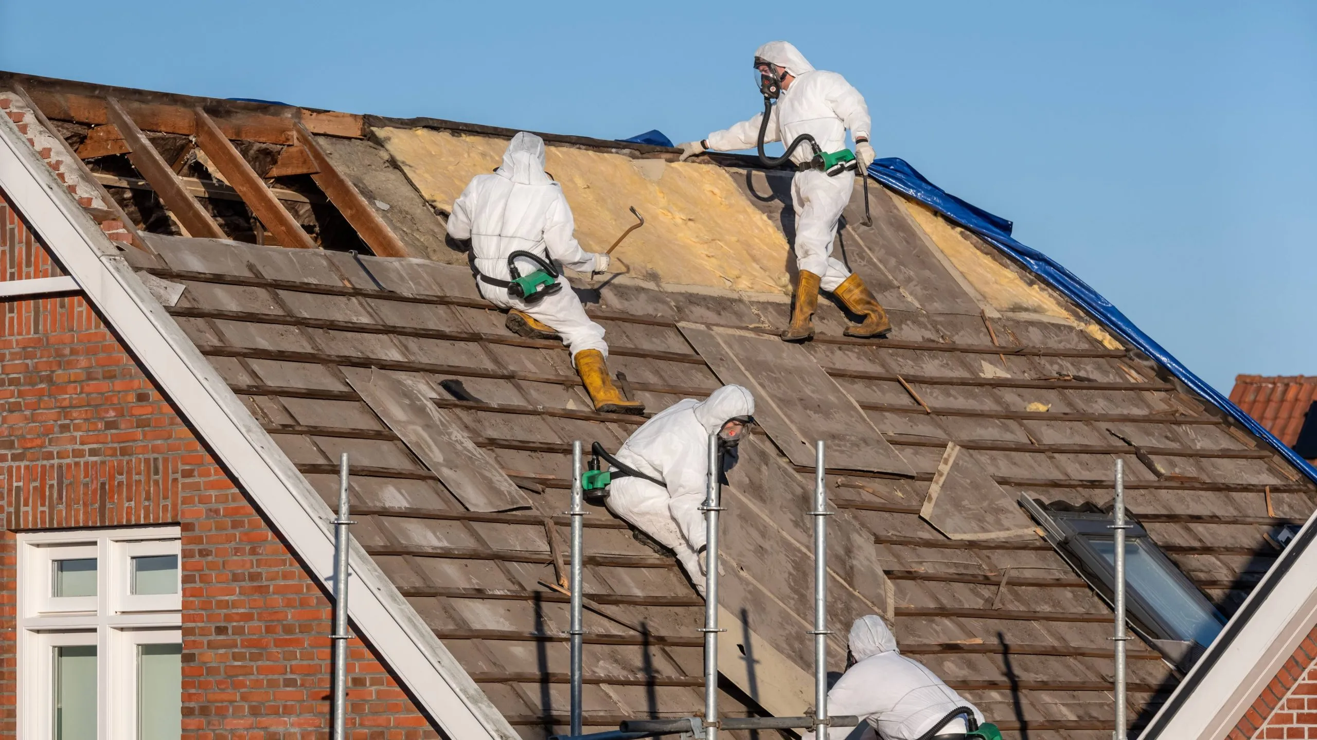 Licensed asbestos removal contractors working on a roof