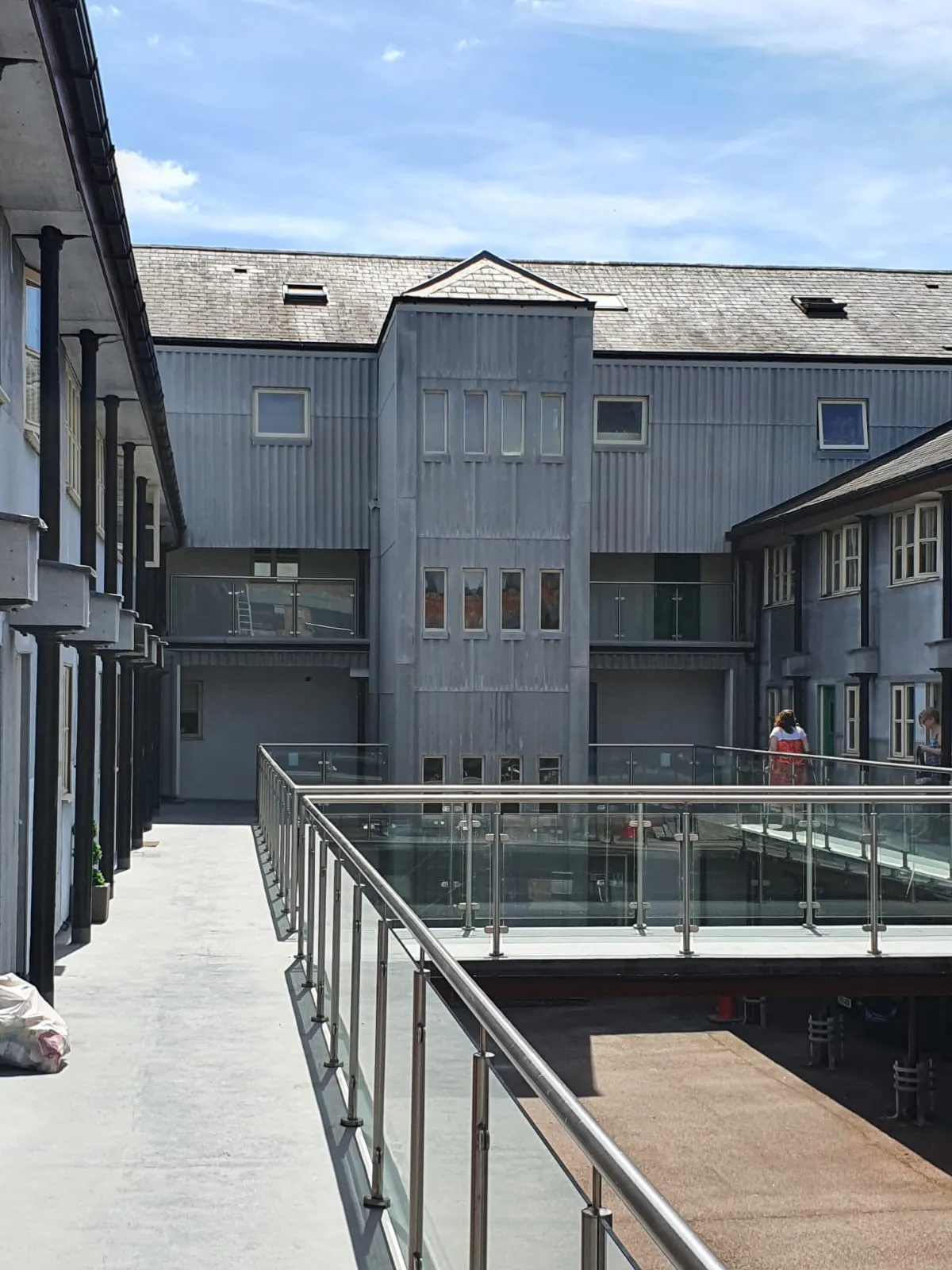 A modern multi-level building with a pitched slate roof and a skylight.