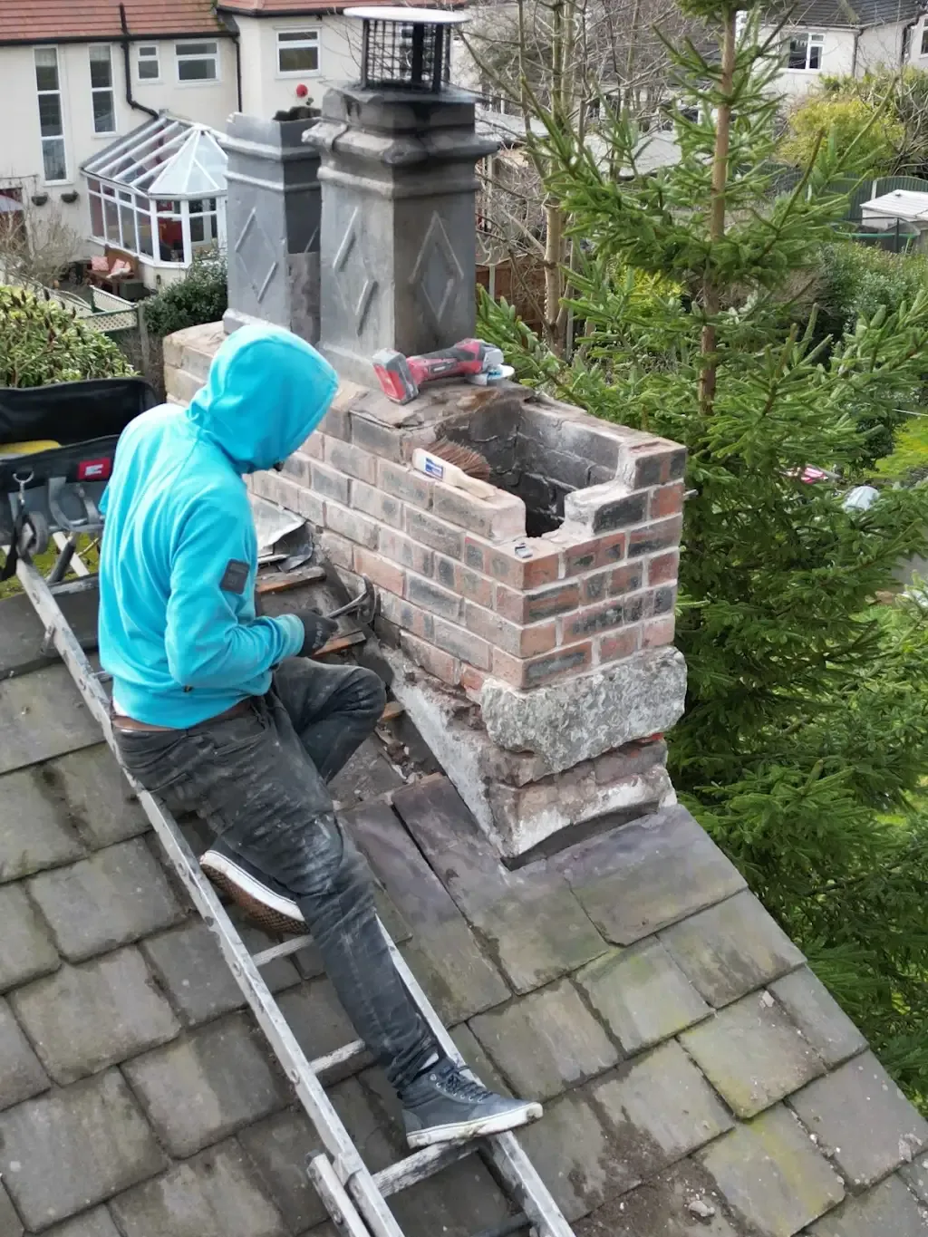 Roofer repairing a brick chimney on a residential roof