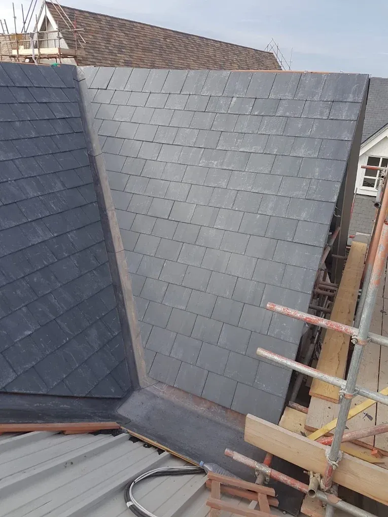 Newly installed slate or tile roofing and valley detail during a pitched roof installation or re-roofing project.