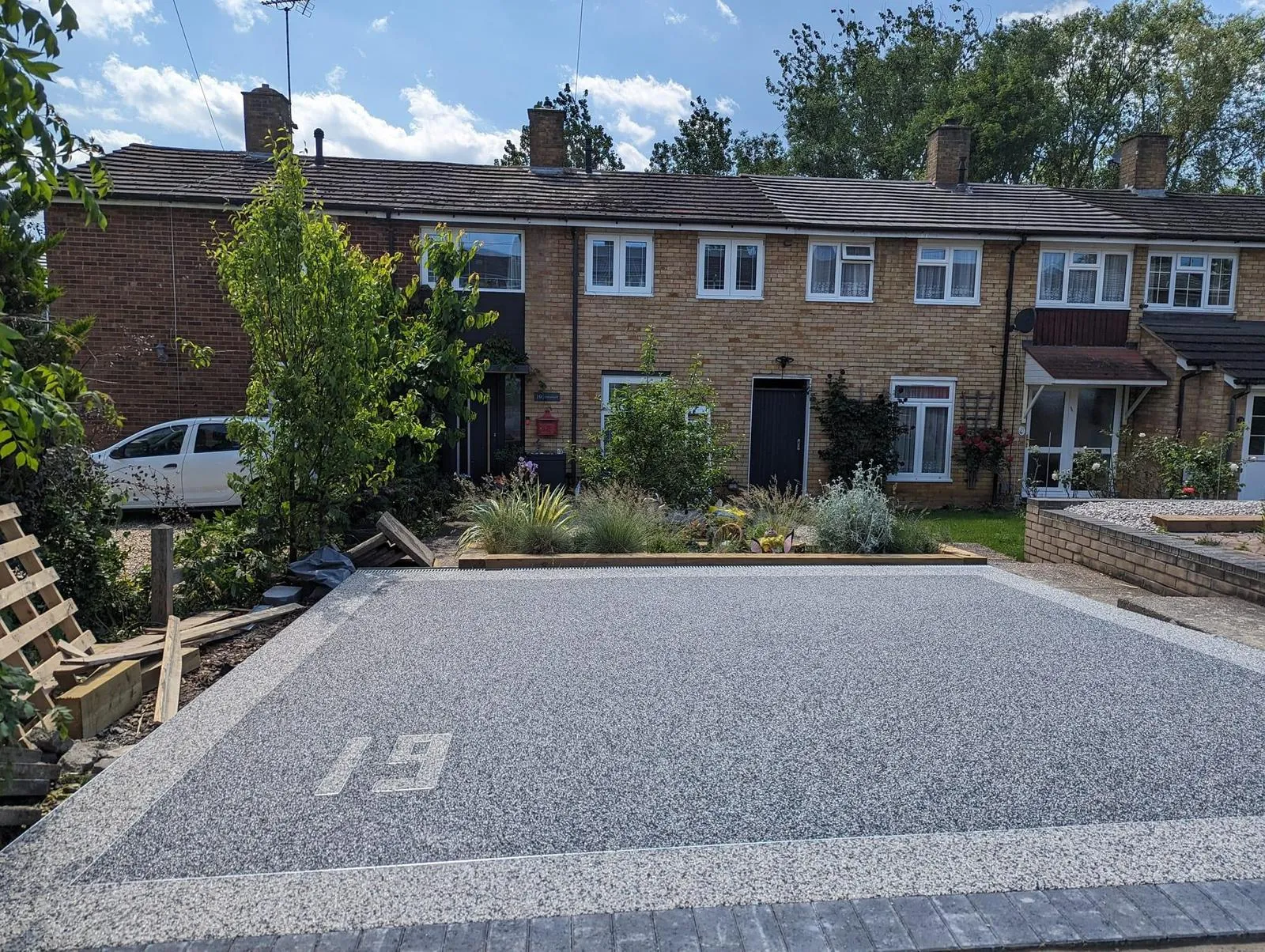 A completed resin-bound driveway with the number 19, leading up to a residential property with a landscaped front garden.