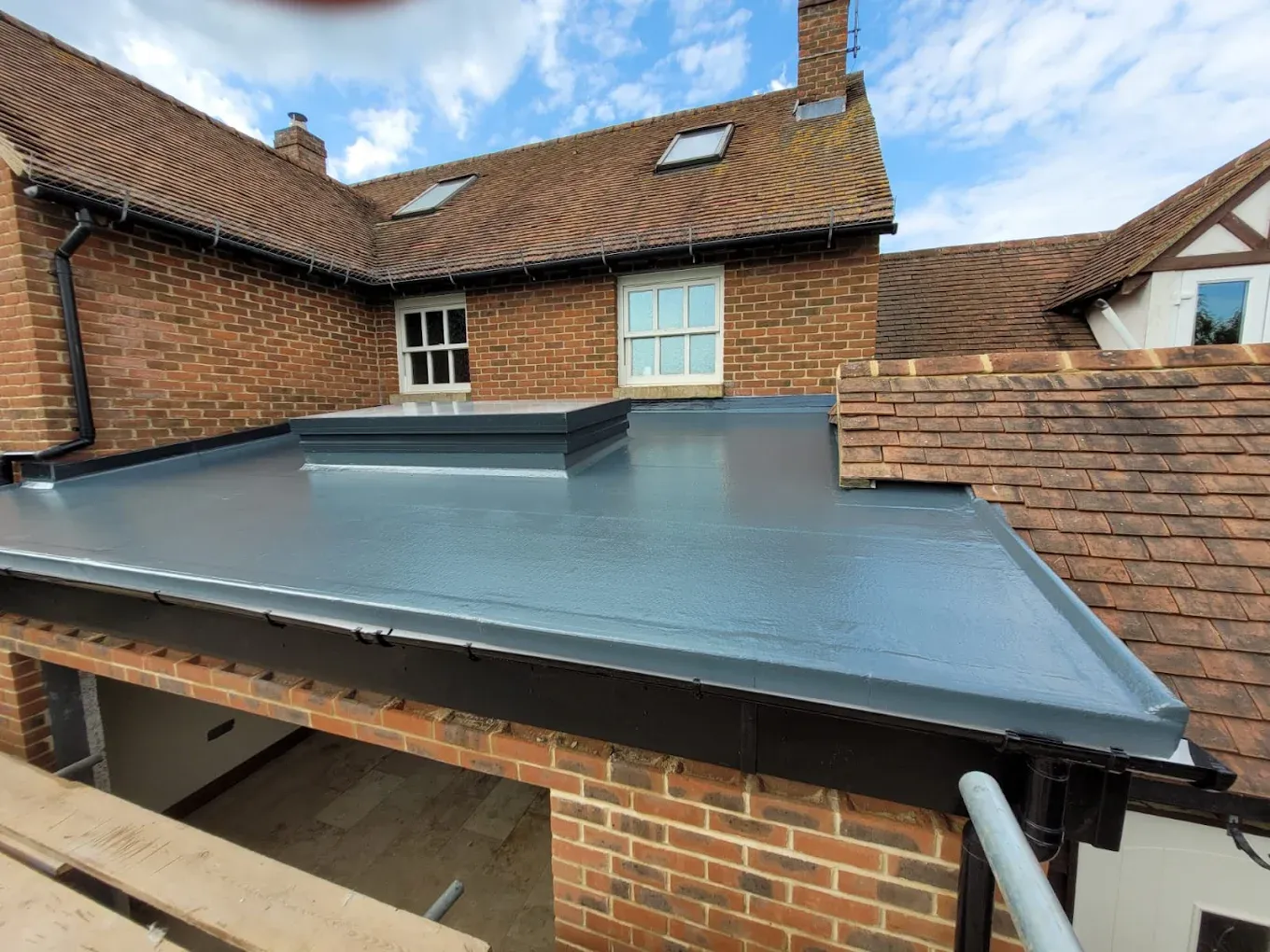 New grey flat roof and rooflight installation on a home extension, showcasing high-quality flat roofing services by Ox Roofing Ltd in Oxfordshire.