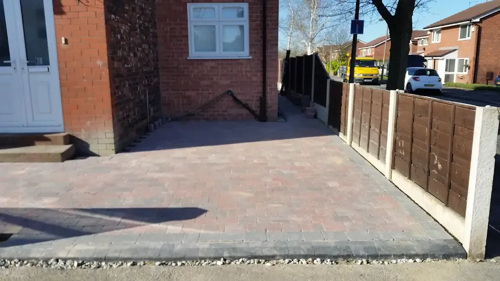 Newly laid block paved driveway and fence in front of a house