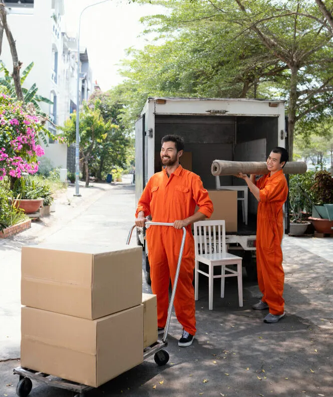 Professional movers loading boxes and furniture into a van for a house removal.