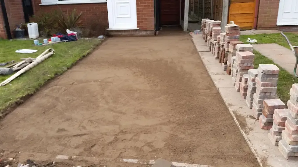 Driveway prepared for block paving with sand layer and stacks of blocks