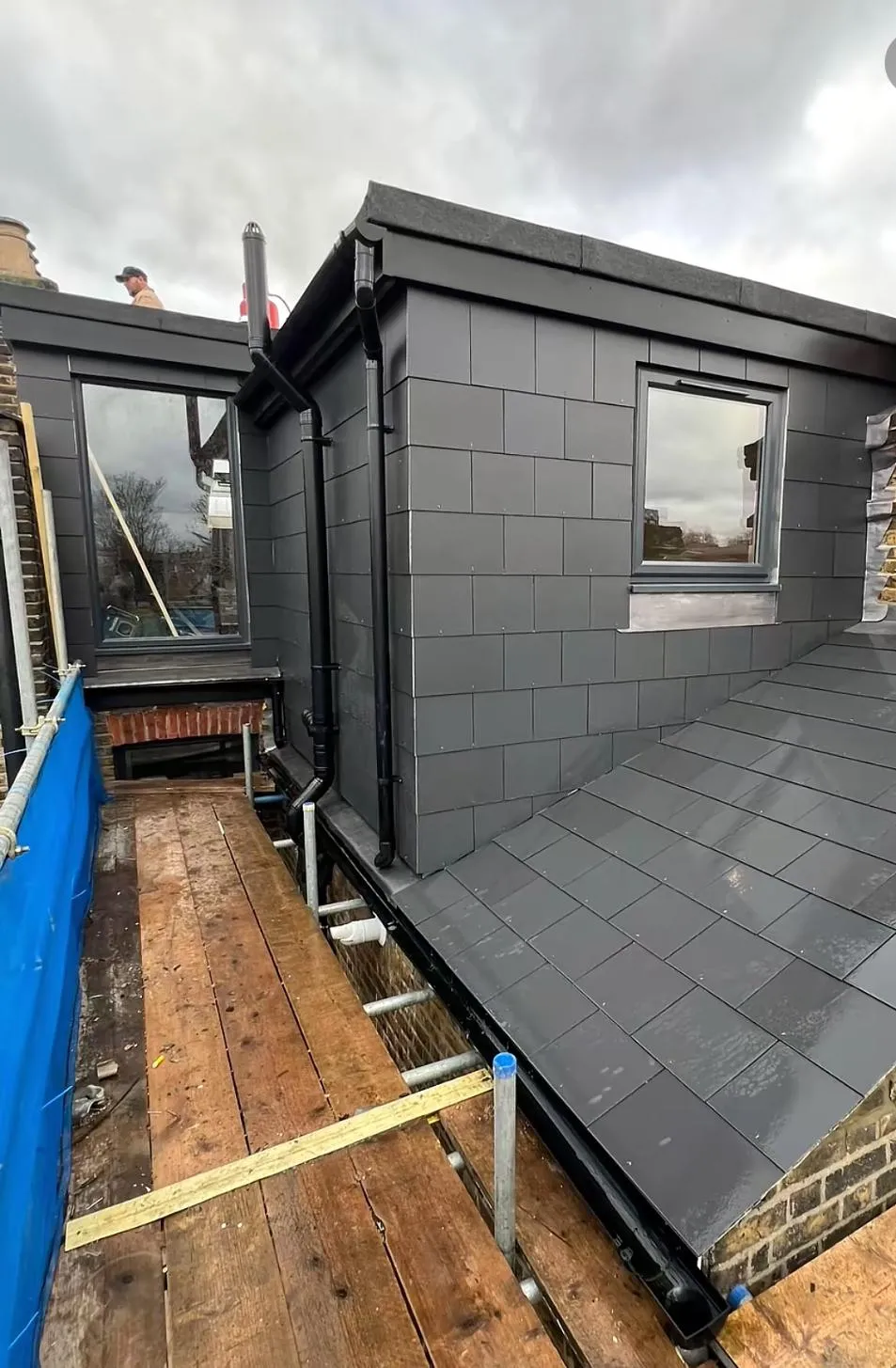 Modern grey tiled pitched roof and flat roof dormer installation with new guttering.