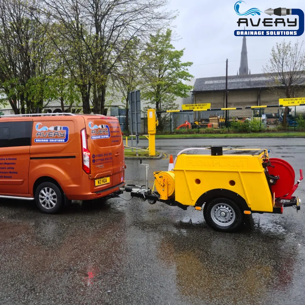 Avery Drainage Solutions van and jetting trailer parked on a road.