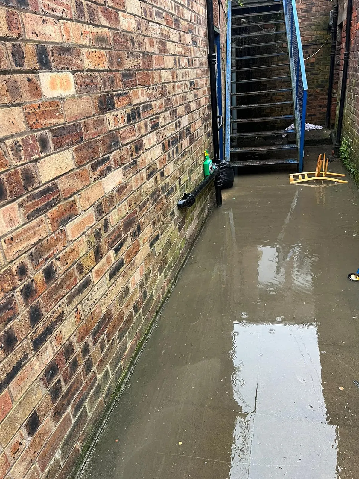 Flooded alleyway caused by blocked drain