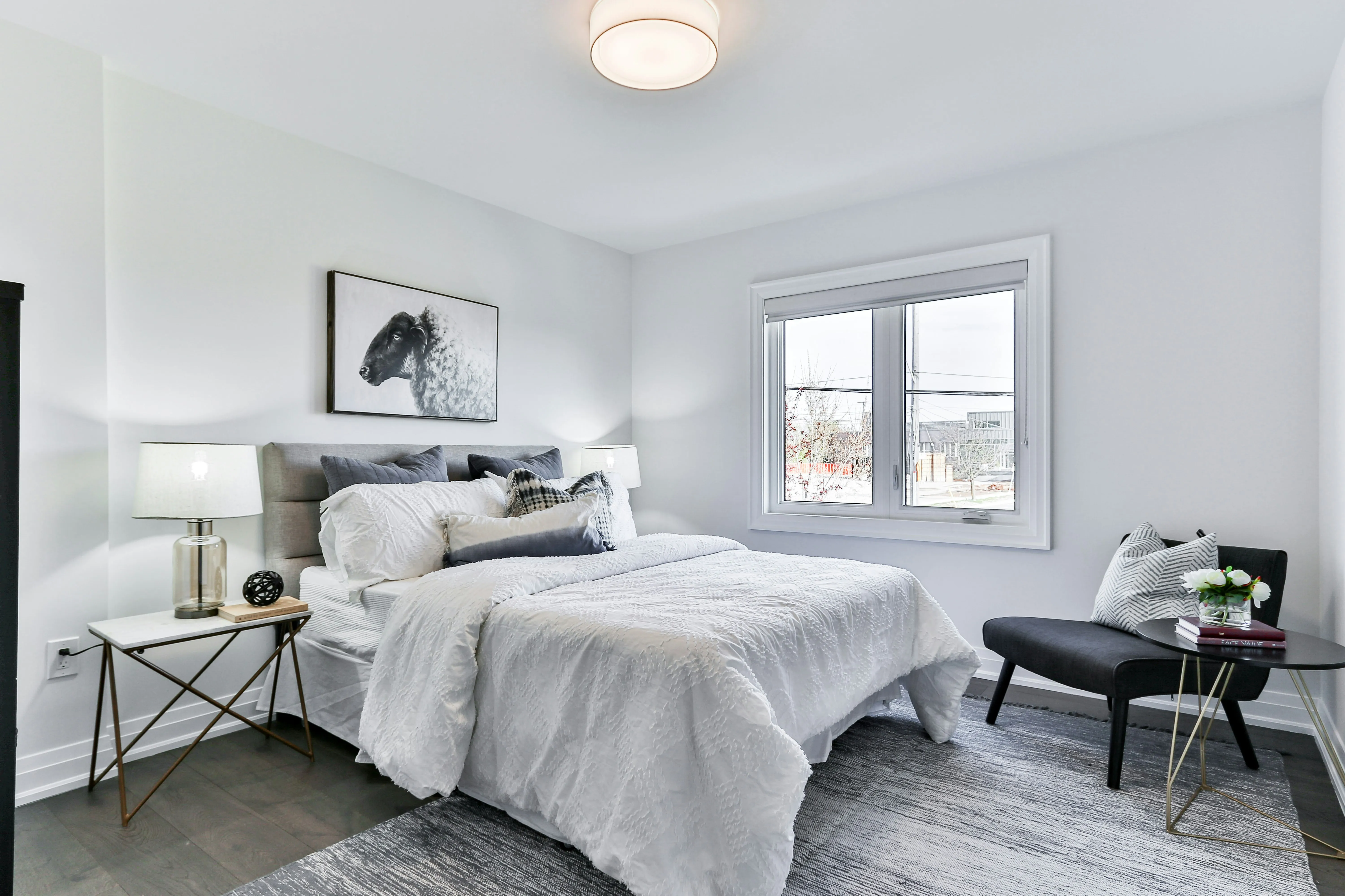 A modern bedroom with a bed, bedside table, and window, a common setting for bed bug treatment services.