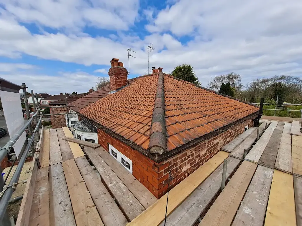 Residential tiled roof with scaffolding during roofing work in Manchester.