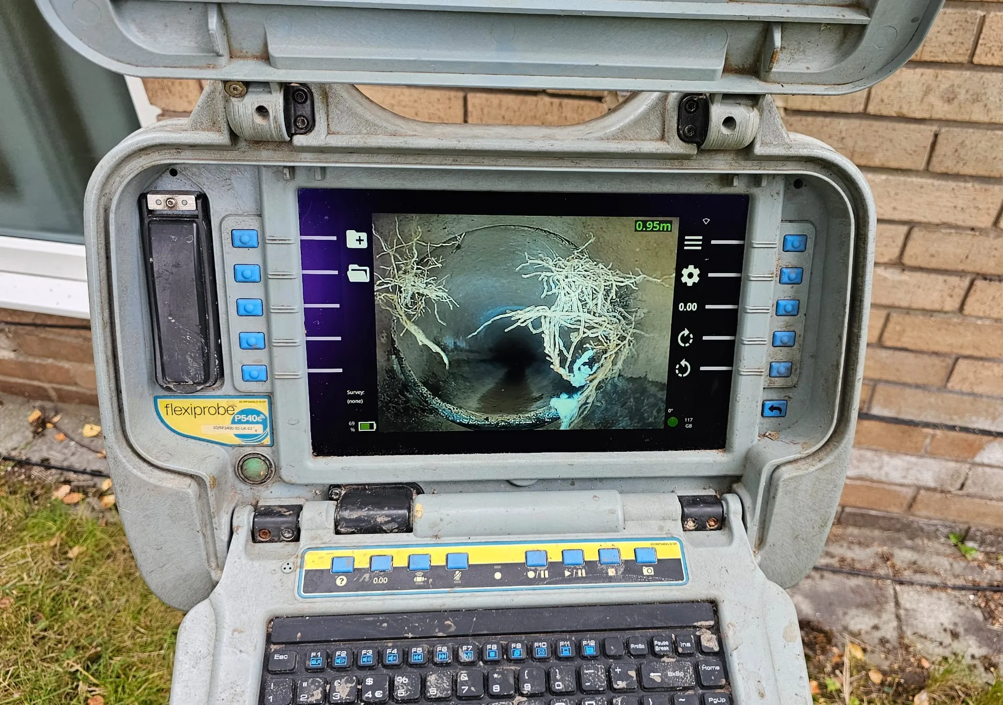 CCTV drain survey equipment screen showing large tree roots inside a pipe, diagnosed by a drainage expert.