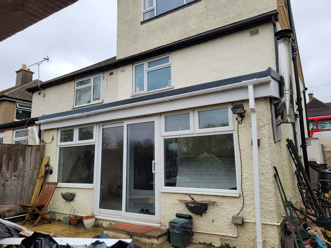 Rear of a house extension with new white UPVC roofline and grey flat roof