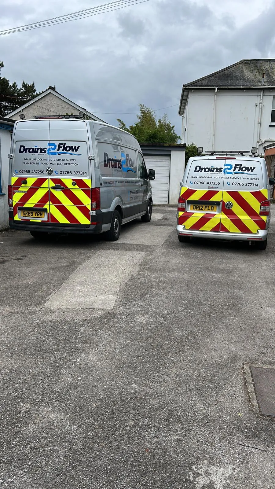Two Drain 2 Flow Exeter drainage vans with company branding and high-visibility markings.