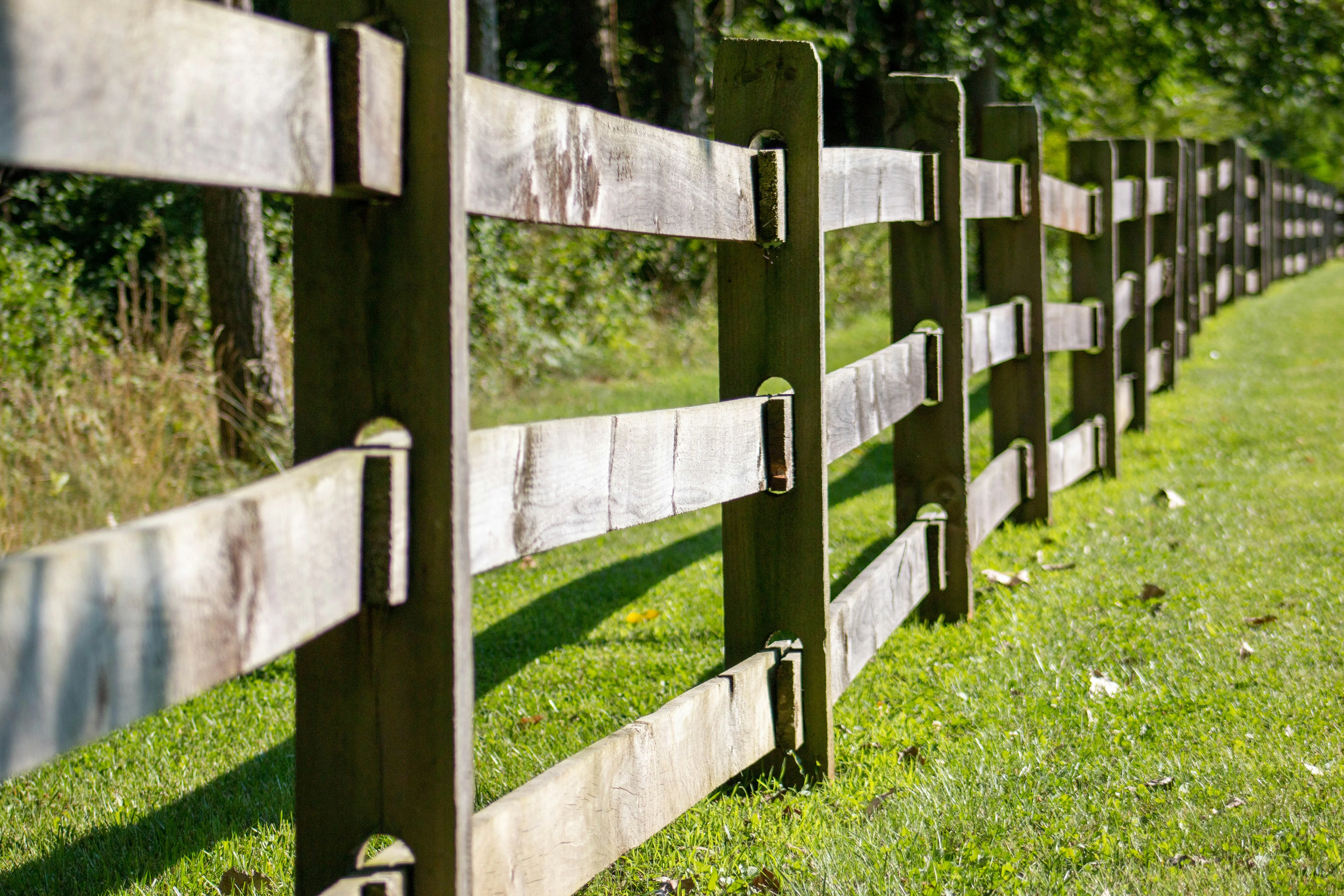A picture of a wooden post and rail fence