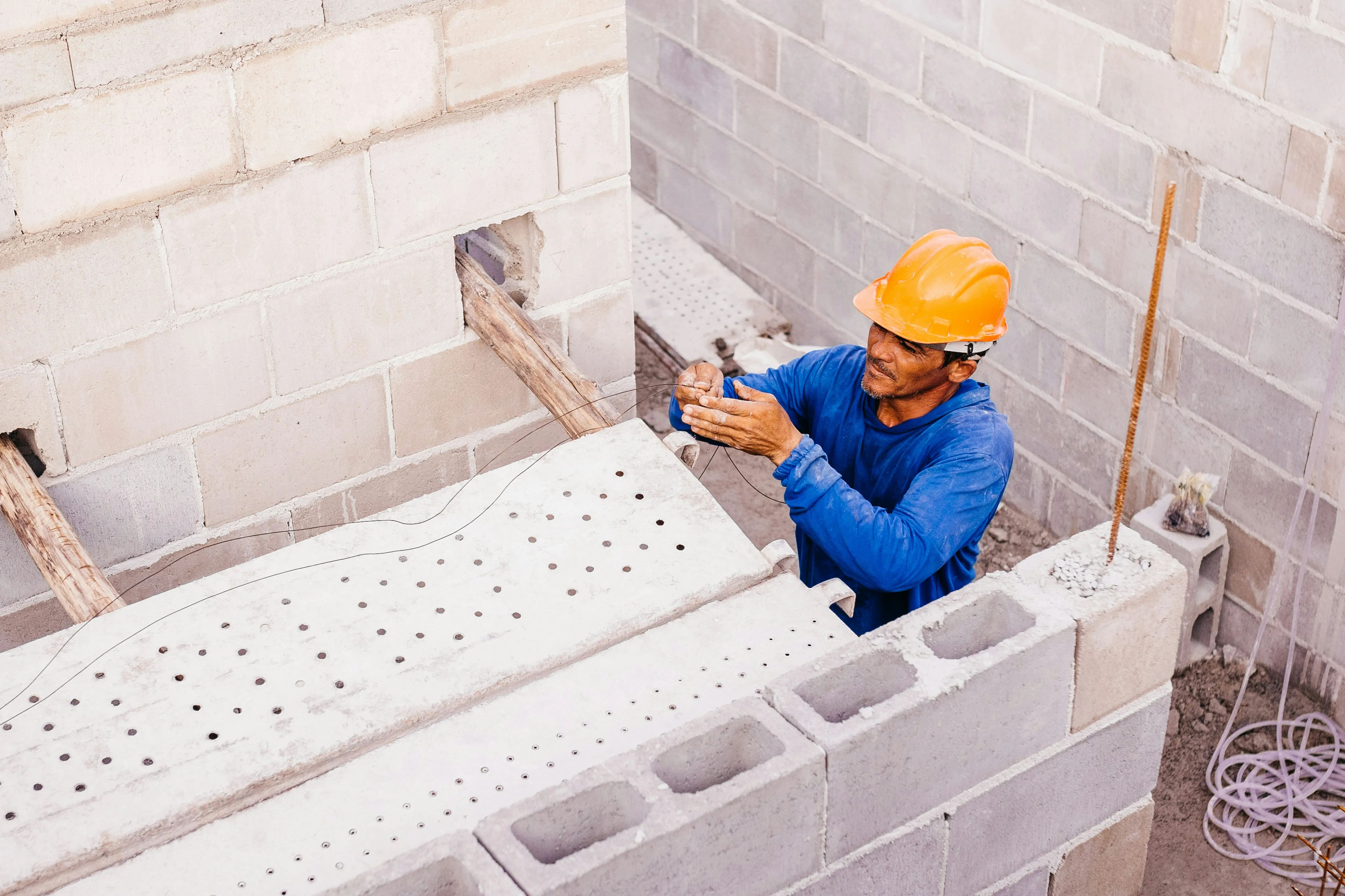 Construction worker building a wall with concrete blocks.