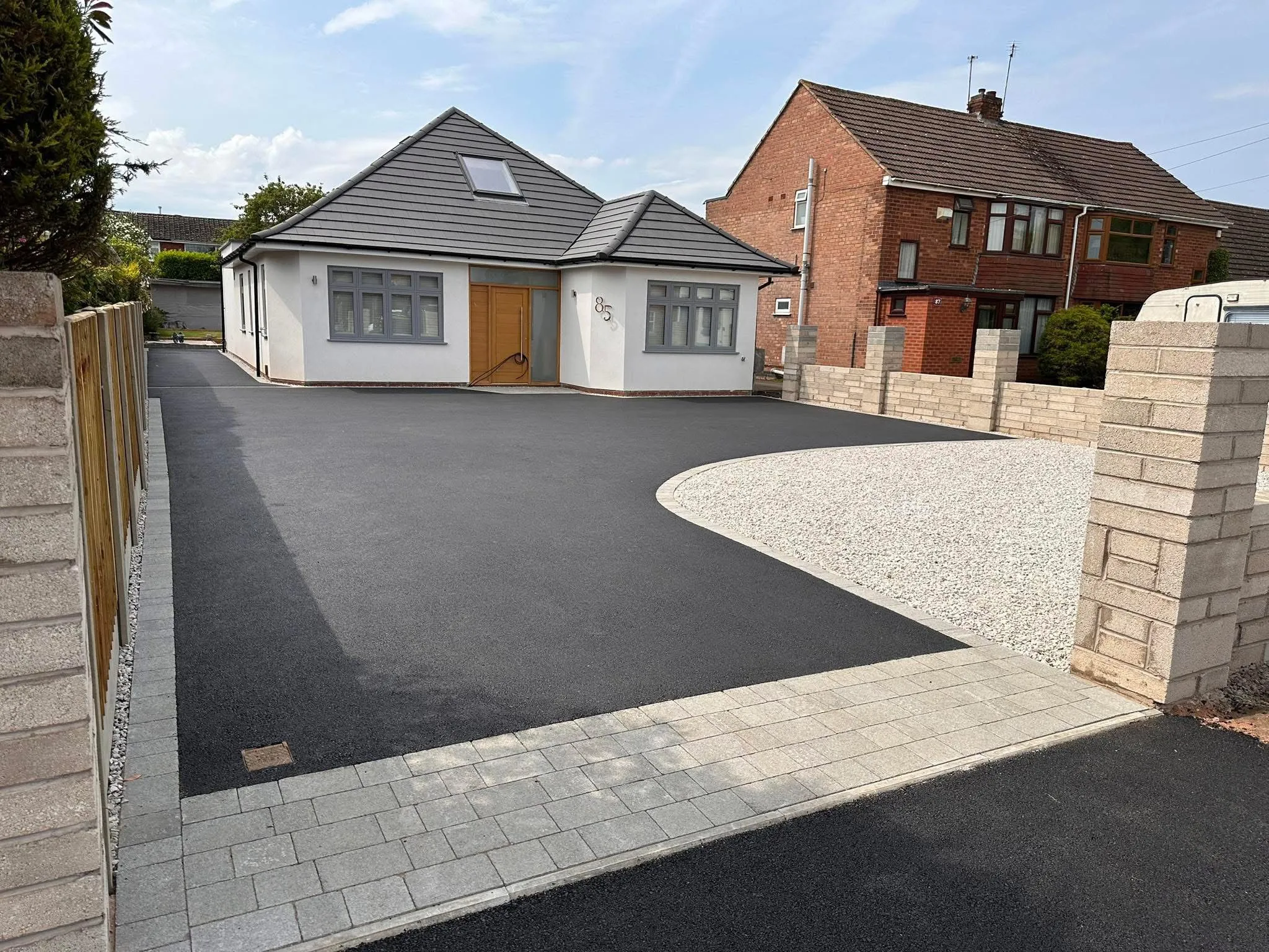 Newly paved driveway with tarmac, gravel, and block paving in front of a modern house.