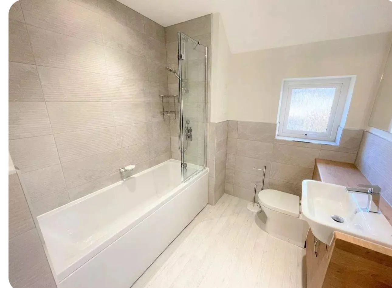 A newly fitted modern bathroom with a bath, shower, toilet, and sink