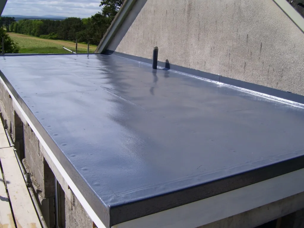 Newly installed flat roof with grey seamless membrane and clean edges by professional roofers.