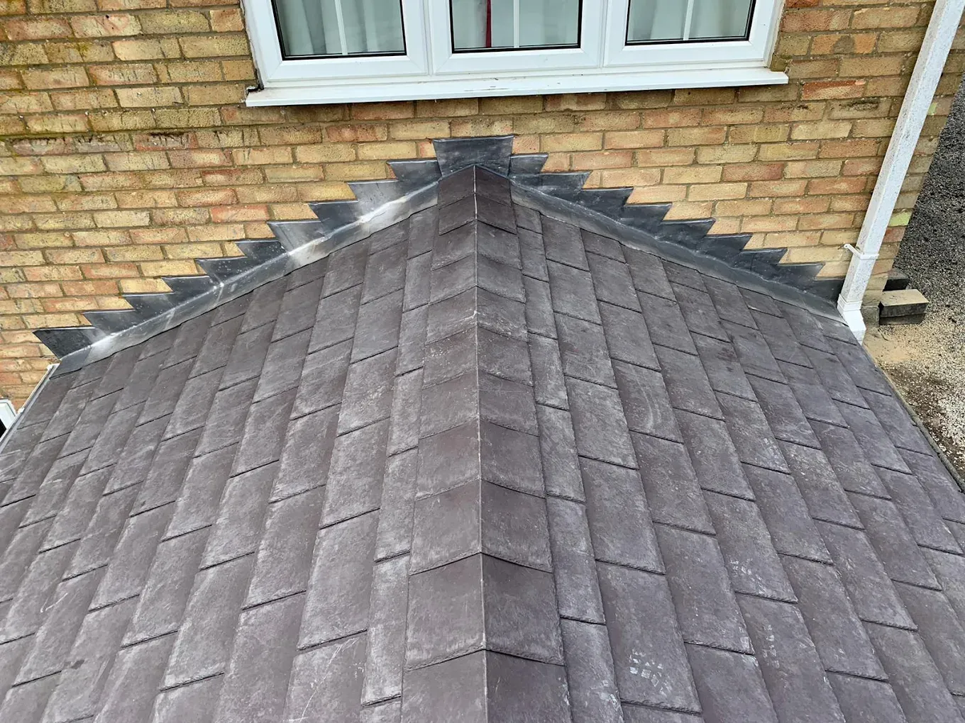 Detailed view of a tiled conservatory roof join with the house wall.