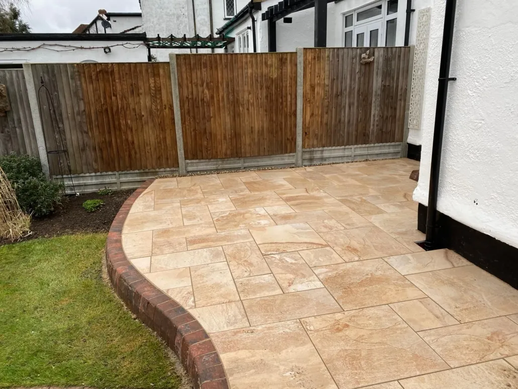 Newly installed patio with paving slabs and curved brick edging