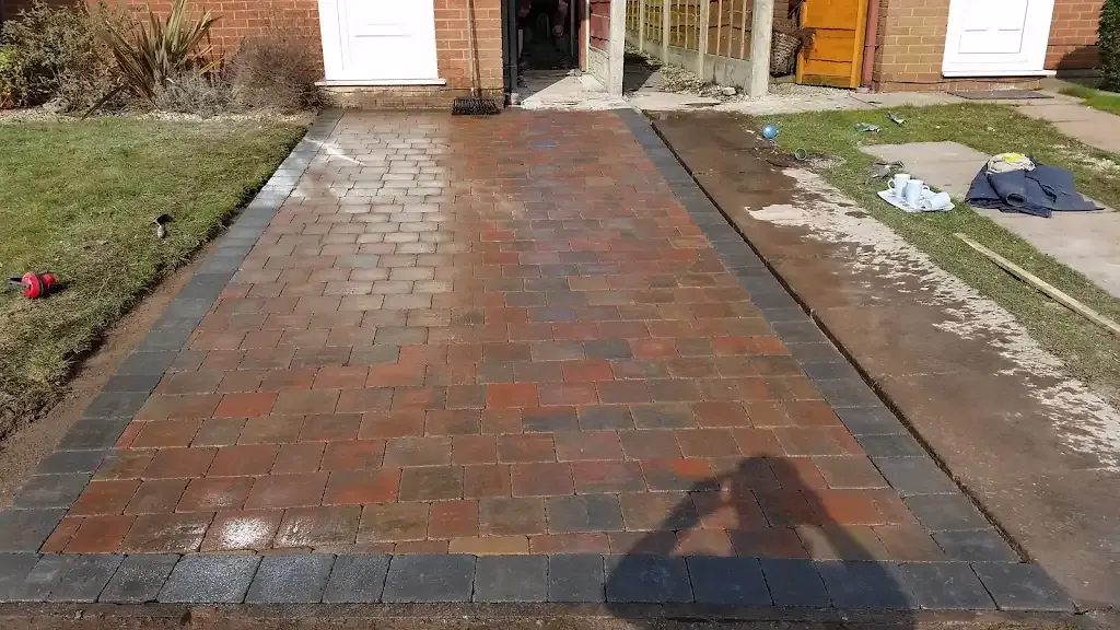 Newly laid block paving driveway with dark grey block edging