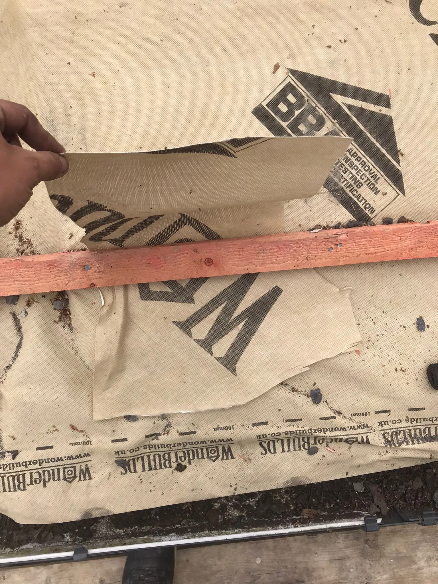 Close-up of a roofer working with breathable roof membrane and wooden battens during a new roof installation or repair by Storm Guard Solutions.