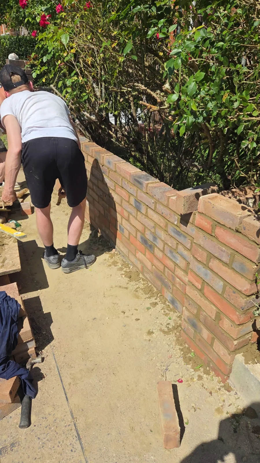 Construction worker building a brick garden wall