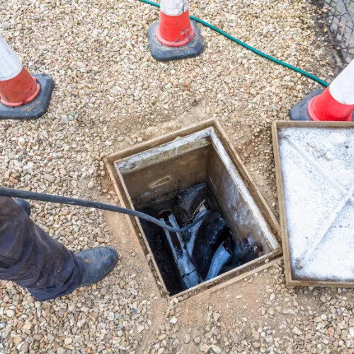 Technician working at a drainage manhole.
