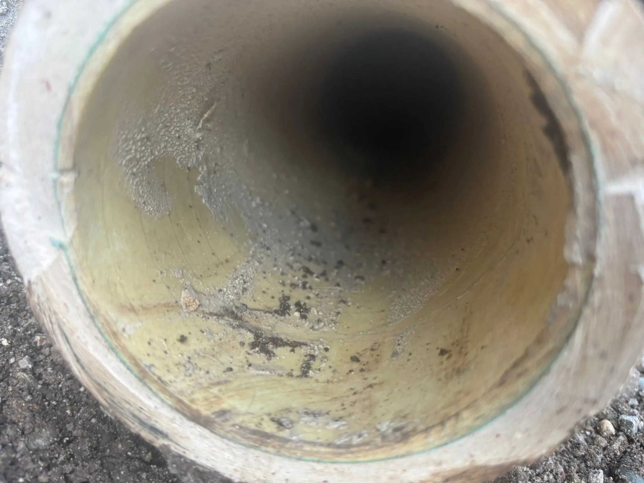Close-up view of the interior of a drain pipe with visible grime and sediment.