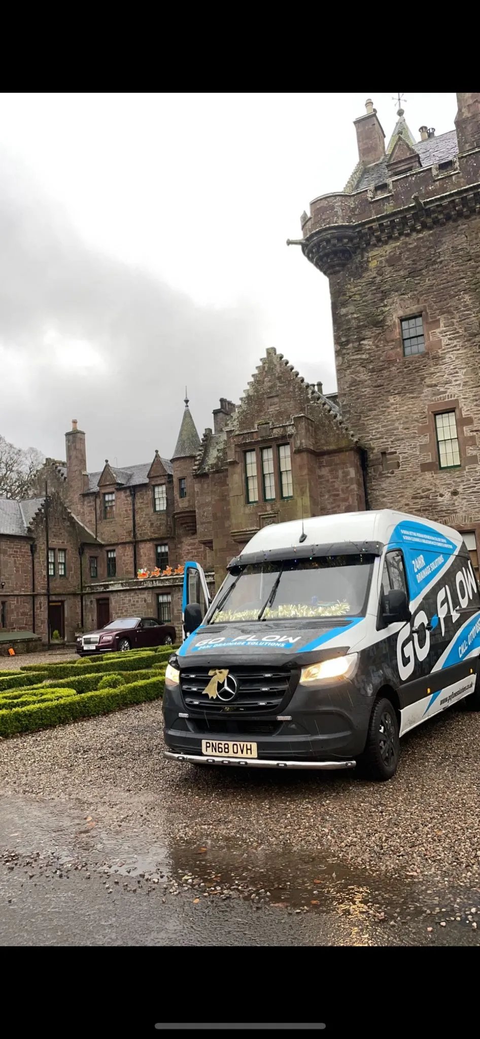 A Go-Flow Drainage Solutions van parked outside a large property