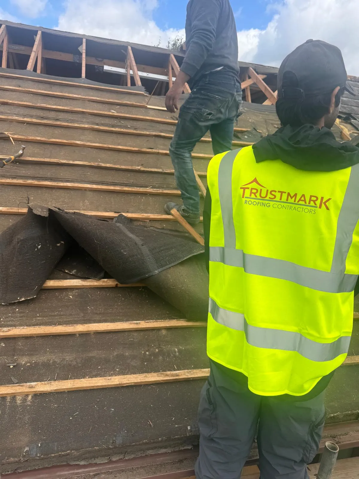 Trustmark Roofing contractors installing a new roof or performing a major roof repair, showing the roof structure, battens, and underlayment.