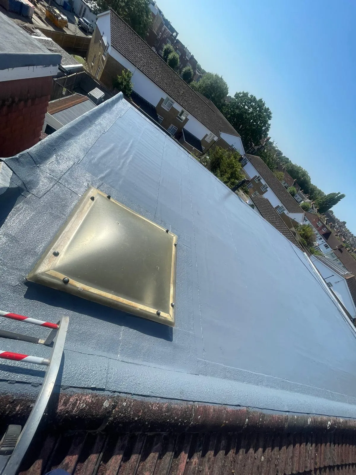 Modern grey flat roof installation with a skylight on a residential property by SD Roofing And Guttering.