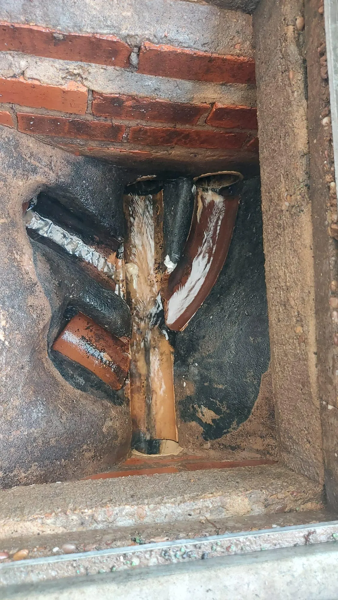 Inside a drain system showing wastewater and FOG buildup on pipes.