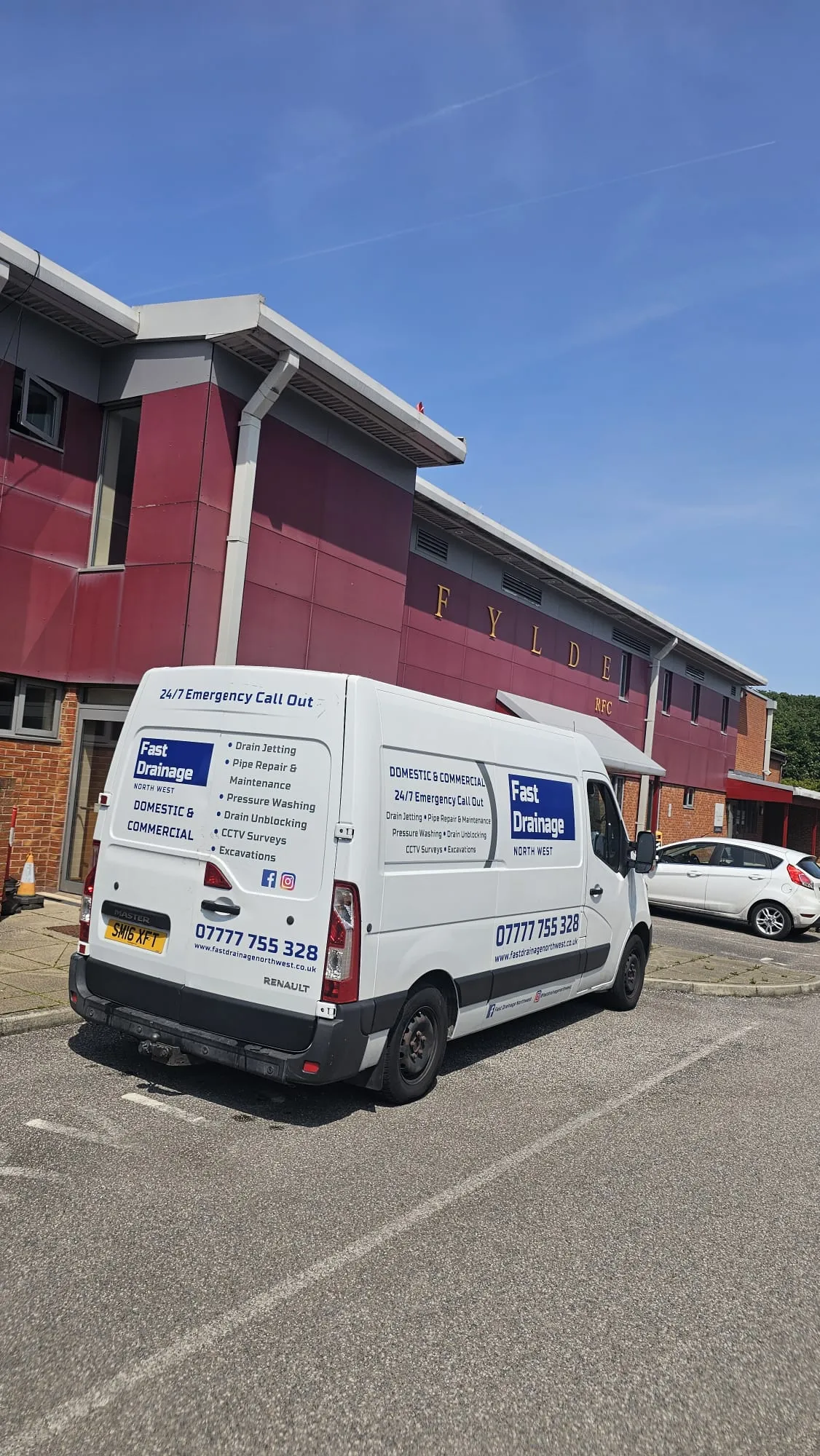 A Fast Drainage Northwest branded service van parked in front of a commercial building